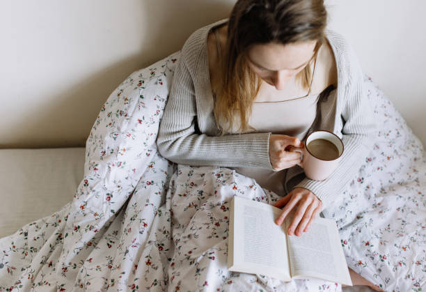 istock Young beautiful woman enjoying with coffee in bed 1221175207