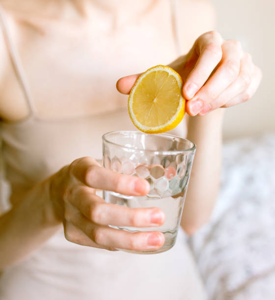 istock Woman drinking water with lemon in the morning 1221175338