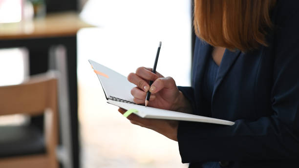 istock Cropped image of beautiful woman working as secretary taking note while sitting in comfortable cafe as background. Comfortable workplace concept. 1221175895