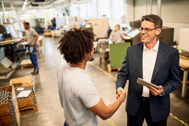 istock Happy engineer and young black worker greeting in industrial building. 1221175911
