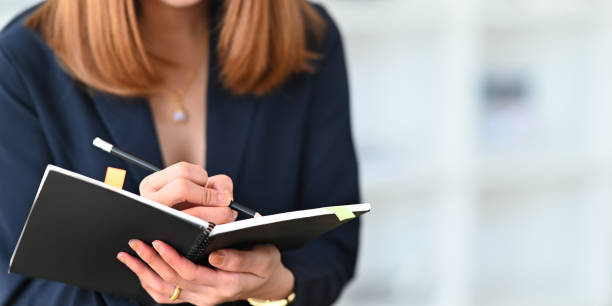 istock Cropped image of beautiful woman working as secretary taking note while sitting in comfortable cafe as background. Comfortable workplace concept. 1221175926