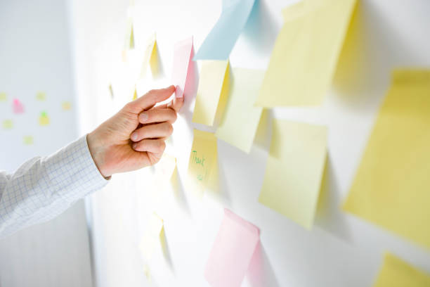 istock Business woman writes notes using post stickers on paper. Brainstorming, teamwork. 1221177510