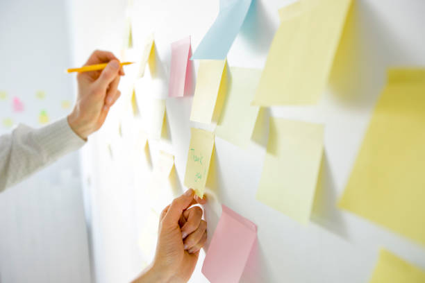 istock Business people write down an important note, using on the paper stickers post. Brainstorming, teamwork. 1221177593