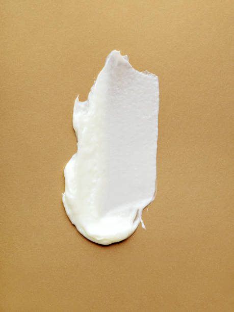 White cream, lotion, moisturiser strokes on glittering gold.