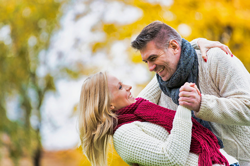 Mature couple enjoying autumn and showing affection in park