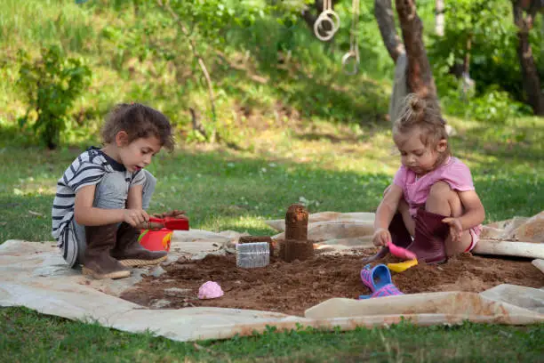 Two little girls building a sandcastle