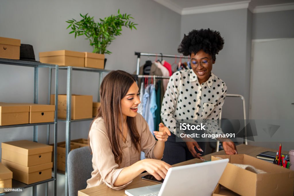 Startup small business owner working with computer at workplace. Startup small business owner working with computer at workplace. Two Freelance women seller check product order, packing goods for delivery to customer. Online selling, e-commerce, shipping concept Computer Stock Photo