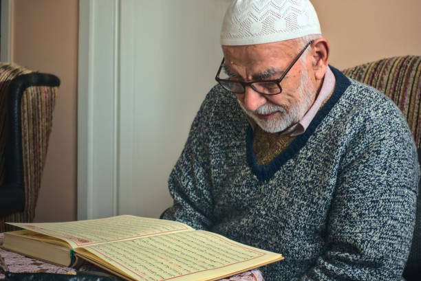 Elderly Turkish muslim male reciting the holy book of Islam, Qur'an in Ramadan stock photo
