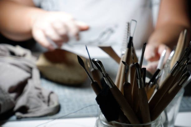 istock Modeling, needle and sgraffito tools of an ceramic artist who works at home at night. 1221191745