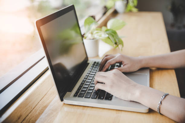 istock Side view of young hipster woman's hands busy working on her laptop 1221192176