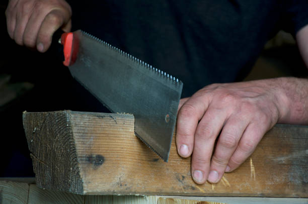 istock carpenter sawing a wooden beam 1221193307