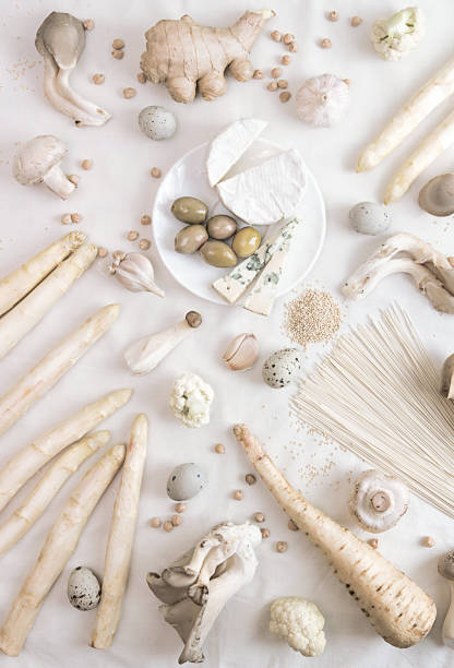istock Plant based modern still life flat lay. Raw vegan ingredients set for cooking on white background: asparagus, mushrooms, eggs, noodles, cheese. Concept white on white. 1221193540