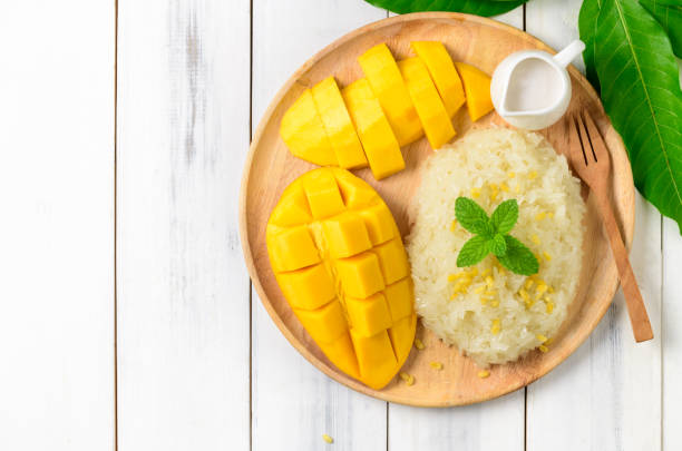 istock Ripe mango and sticky rice with coconut milk on white wood background 1221195589