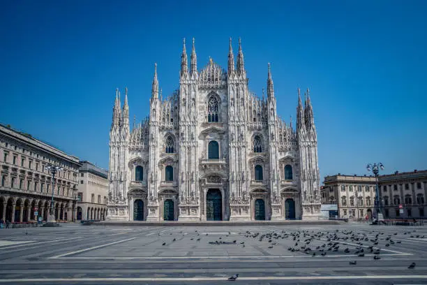 Photo of Empty streets due to covid-19 virus. Lockdown in european town. Strange spring in Milan piazza Duomo Italy. Report from deserted cities people are locked up. Nobody can go out all are closed at home