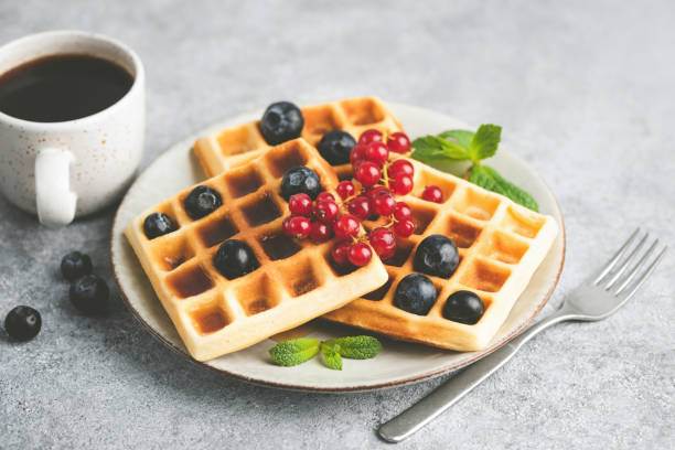 istock Belgian waffles with berries and cup of coffee 1221198250