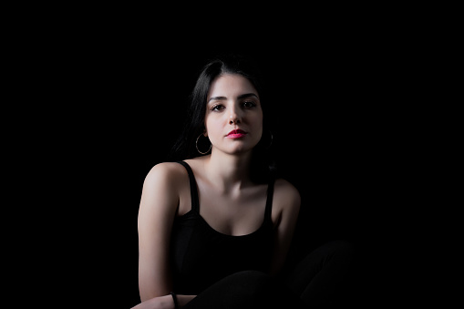 Young woman looking at camera isolated on black background. Beautiful woman portrait.