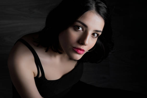 istock Young woman looking at camera isolated on black background 1221199403