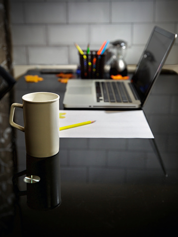 Coffee mug and laptop in office table. Copy Space in Background.