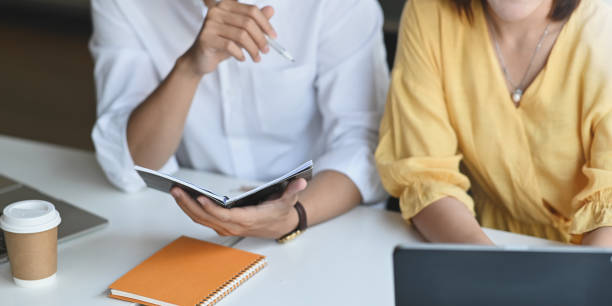 istock Close-up business consulting team working together with computer tablet while sitting at the long working desk over modern office as background. 1221202356