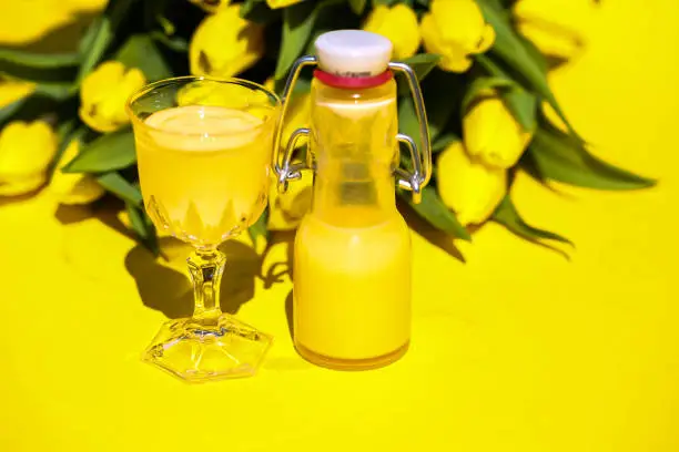 Eggnog with yellow tulips on a yellow background