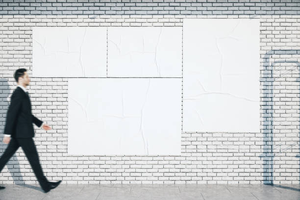 istock Businessman walking near blank three white posters 1221205626