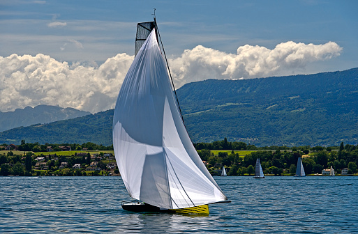 Sailing boat flying masthead spinnaker on a lake