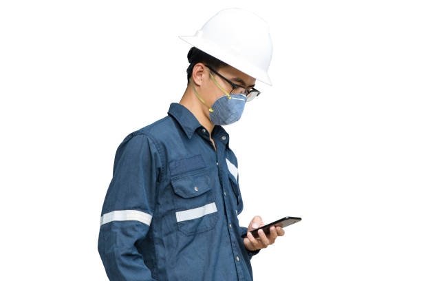 istock Asian Engineer wearing face mask N95 protect filter pm2.5 anti pollution, anti smog and viruses. Air pollution, working with smart phone concept isolated on white background. 1221206298
