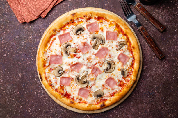 Pizza with ham and mushrooms on concrete table top view