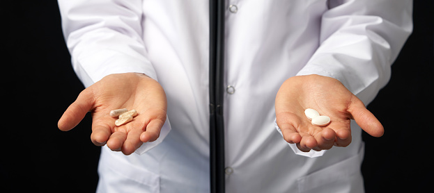 Doctor Hands with Pills. Difficult Choice between drugs. Placebo drugs concept. Healthcare concept.