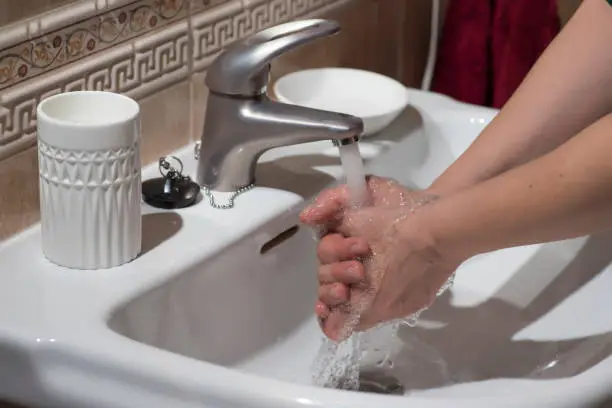 Photo of Hand washing under running water, for good cleaning and hygiene.