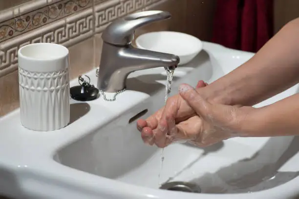 Photo of Hand washing under running water, for good cleaning and hygiene.