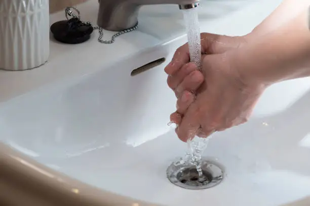 Photo of Hand washing under running water, for good cleaning and hygiene.