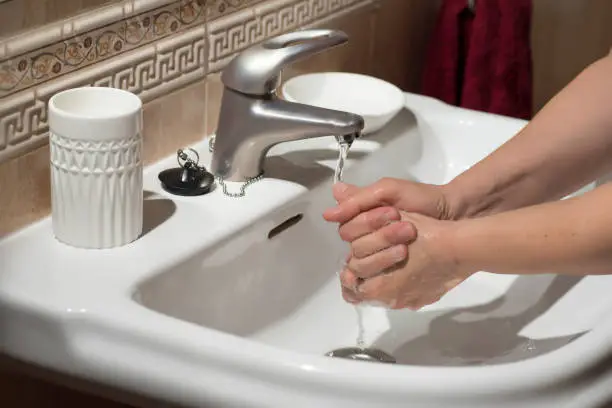 Photo of Hand washing under running water, for good cleaning and hygiene.
