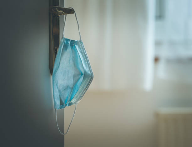 istock Face mask concept: Surgical mask on at home, door handle 1221208539