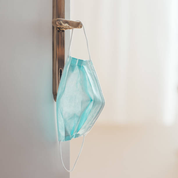 istock Face mask concept: Surgical mask on at home, door handle 1221208836