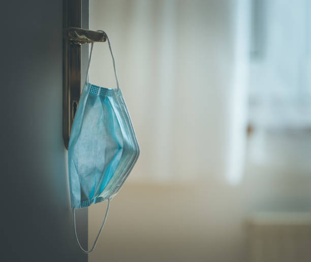 istock Face mask concept: Surgical mask on at home, door handle 1221208890