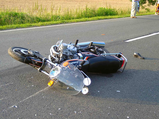 Moto rotta sdraiata su strada dopo incidente mortale - foto stock