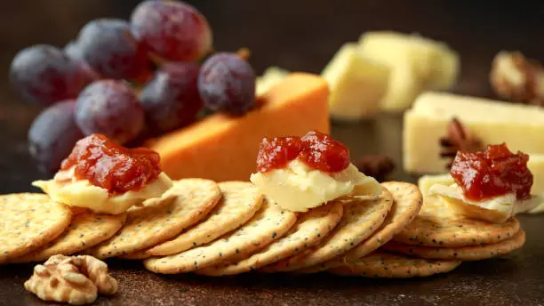 stack of crackers with apple chutney and other snacks.
