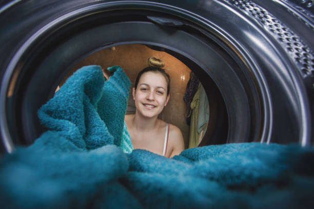 istock Woman filling washing machine with laundry 1221210267