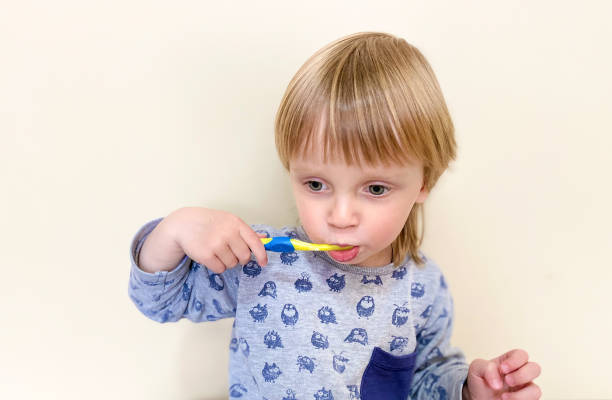 istock Little fair-skinned child brushing his teeth, on a light background. 1221210432