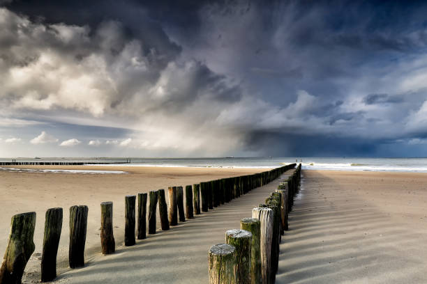 nubes de ducha sobre la playa del mar del norte, países bajos - mammatus cloud fotografías e imágenes de stock