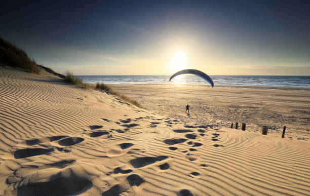 istock man with paraglider on beach by sea at sunset 1221210757