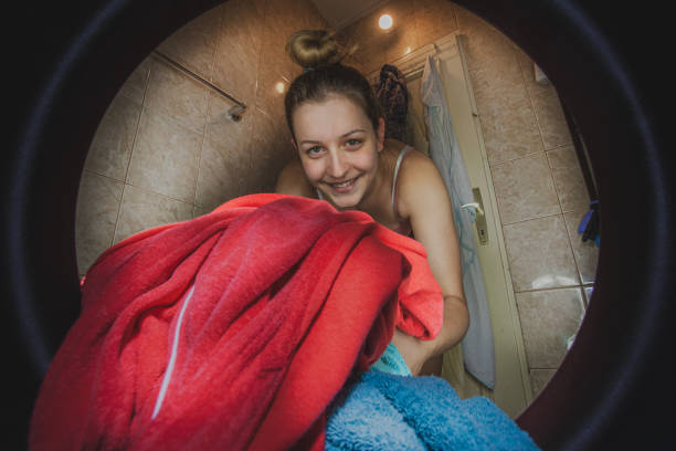 istock Woman filling washing machine with laundry 1221210857