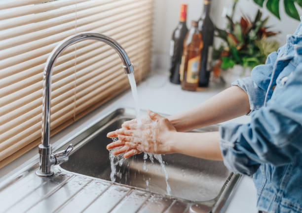 istock Woman washing hands in sink 1221210910