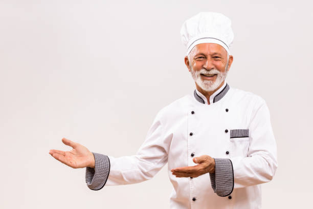 istock Senior chef showing welcome gesture 1221211900