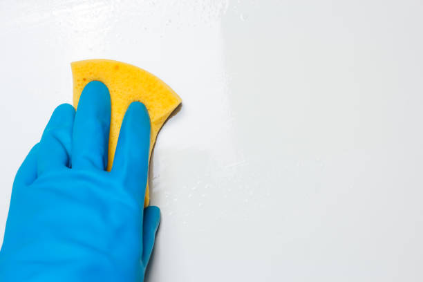 istock Close up view of hand with rubber glove cleaning white table. Copy space 1221213371