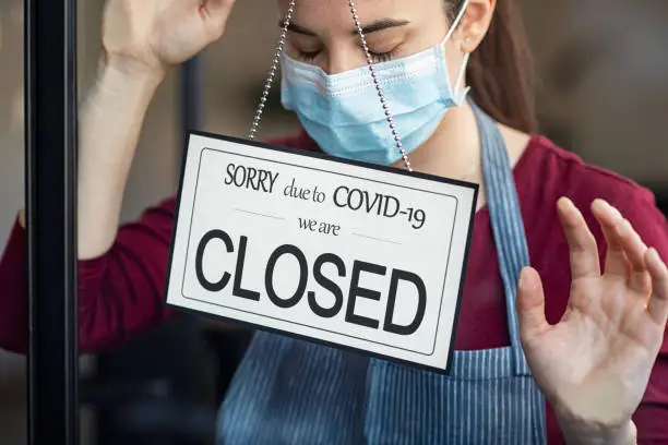 Stressed owner forced to close the restaurant permanently due to restrictions on the coronavirus. Depressed businesswoman closing her business activity due to covid-19. Small business closes its doors due to quarantine damage: bankrupt and failure.