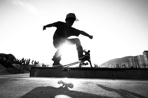 Skateboarder training on a track photographed in black and white.