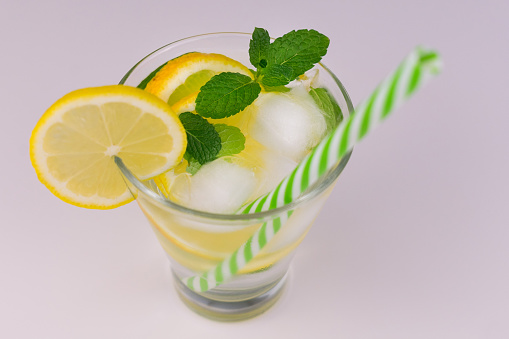 A refreshing drink made from mint lemons and ice on a white background.