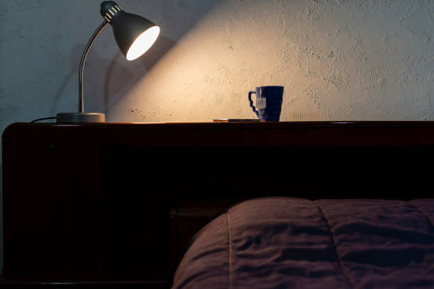 istock Lamp over wooden headboard and bed. Working from home 1221216322